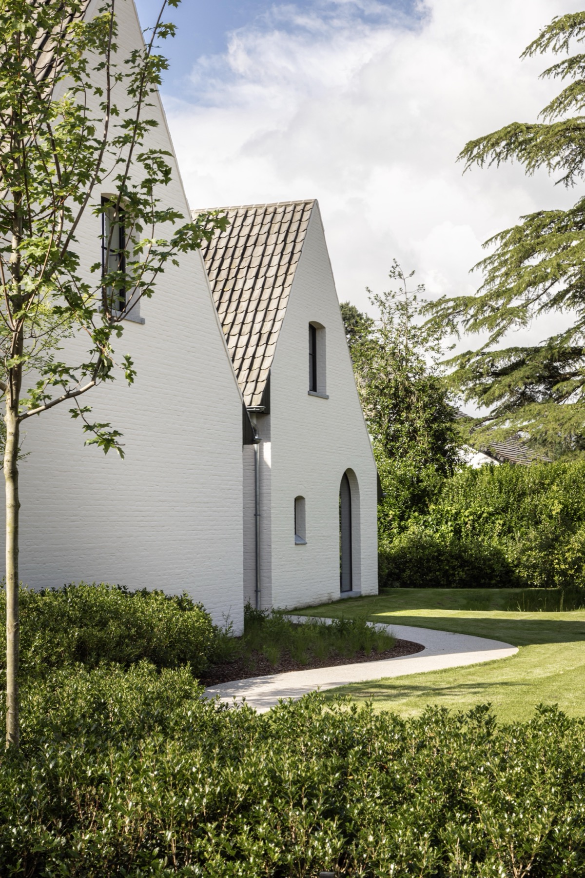 Witte woning met steile puntgevel en tuinpad