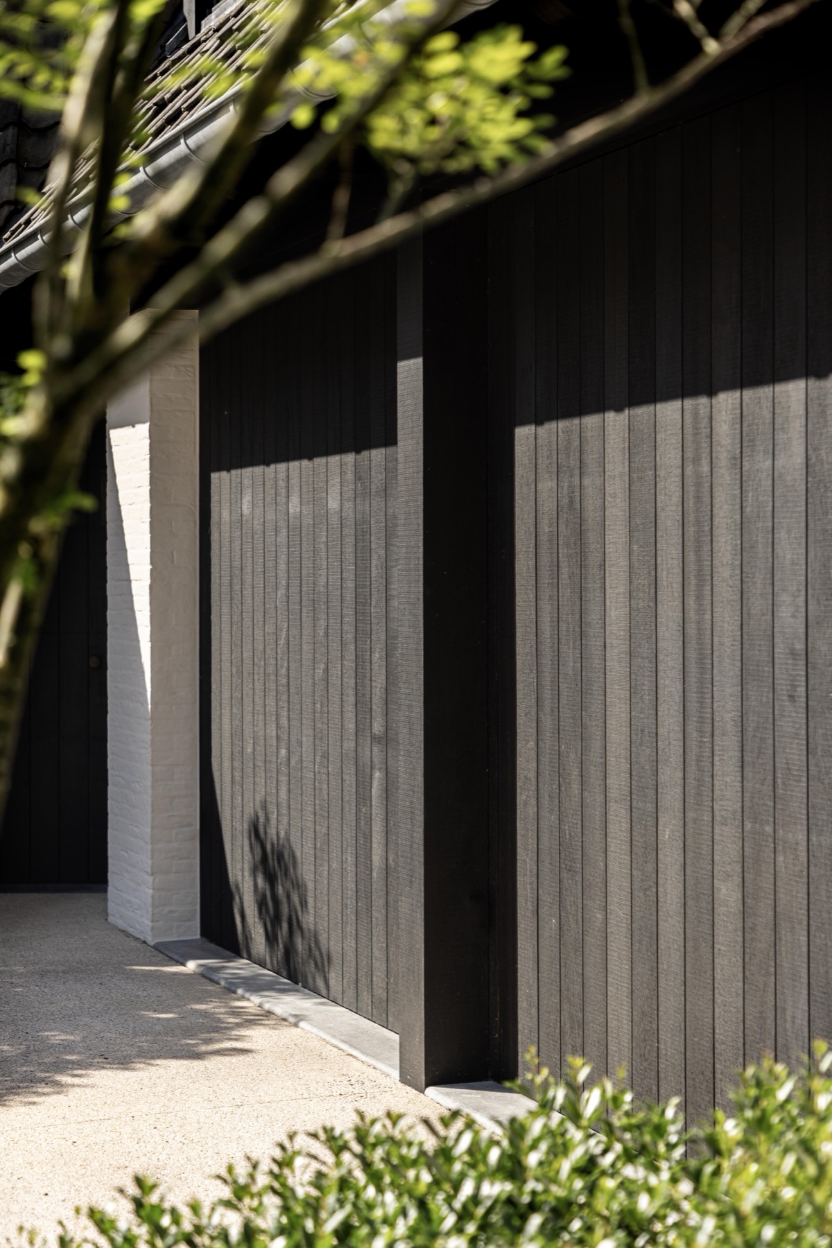 Detail van de zwart gebeitste verticale houtbekleding