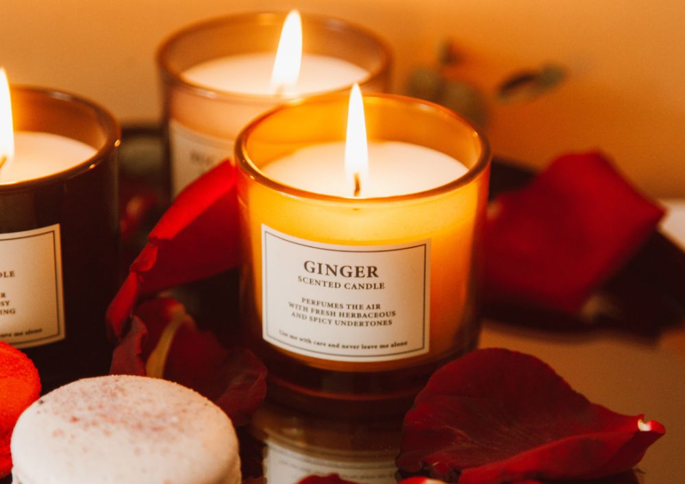 Three candles on a tray surrounded by rose petals, creating a romantic and serene ambiance.
