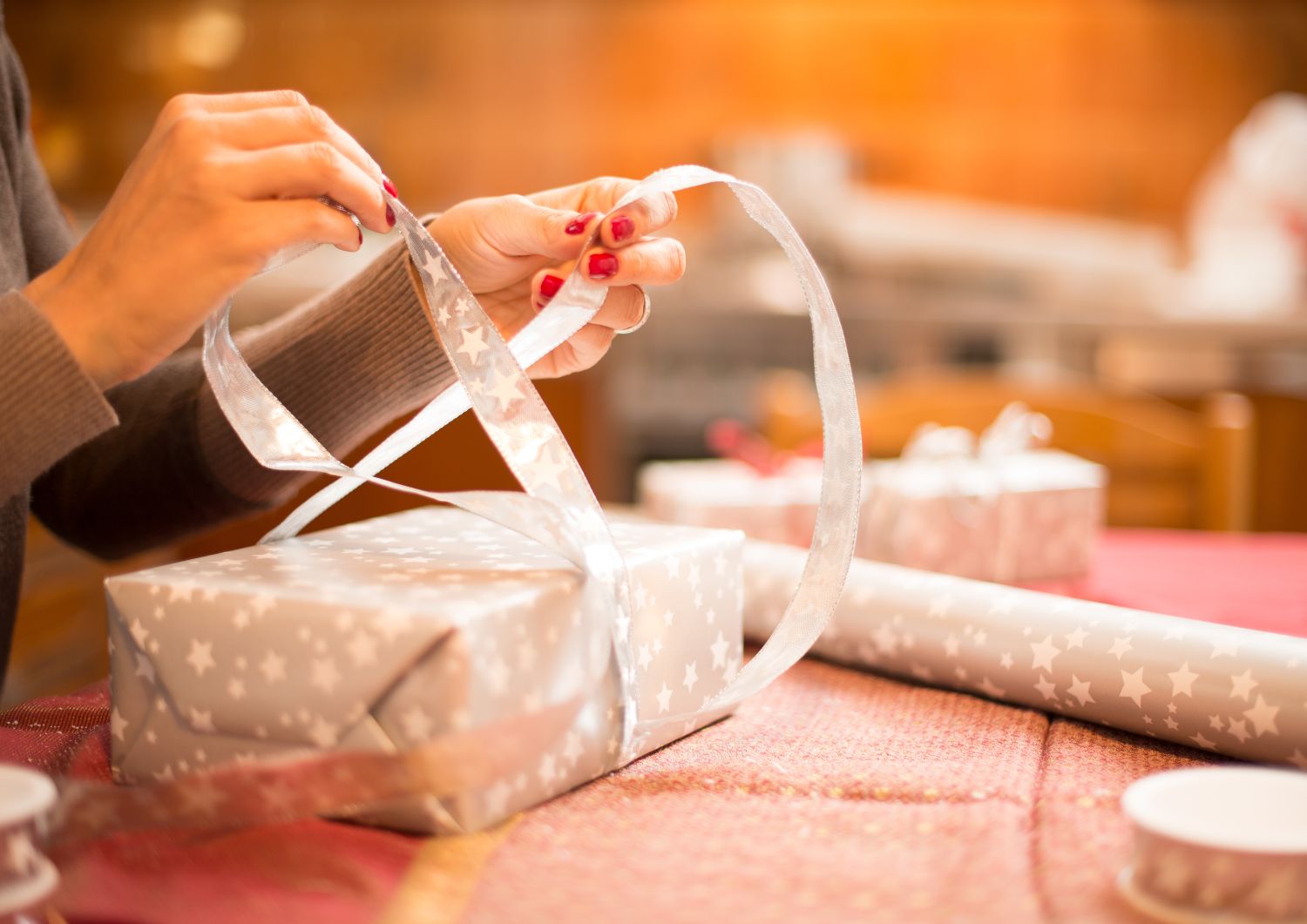 Present being wrapped with bow by woman