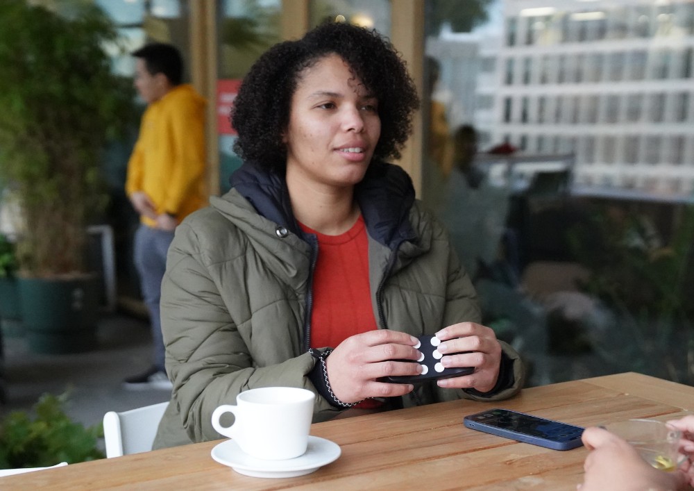 A blind woman happily using the hable one in a public place