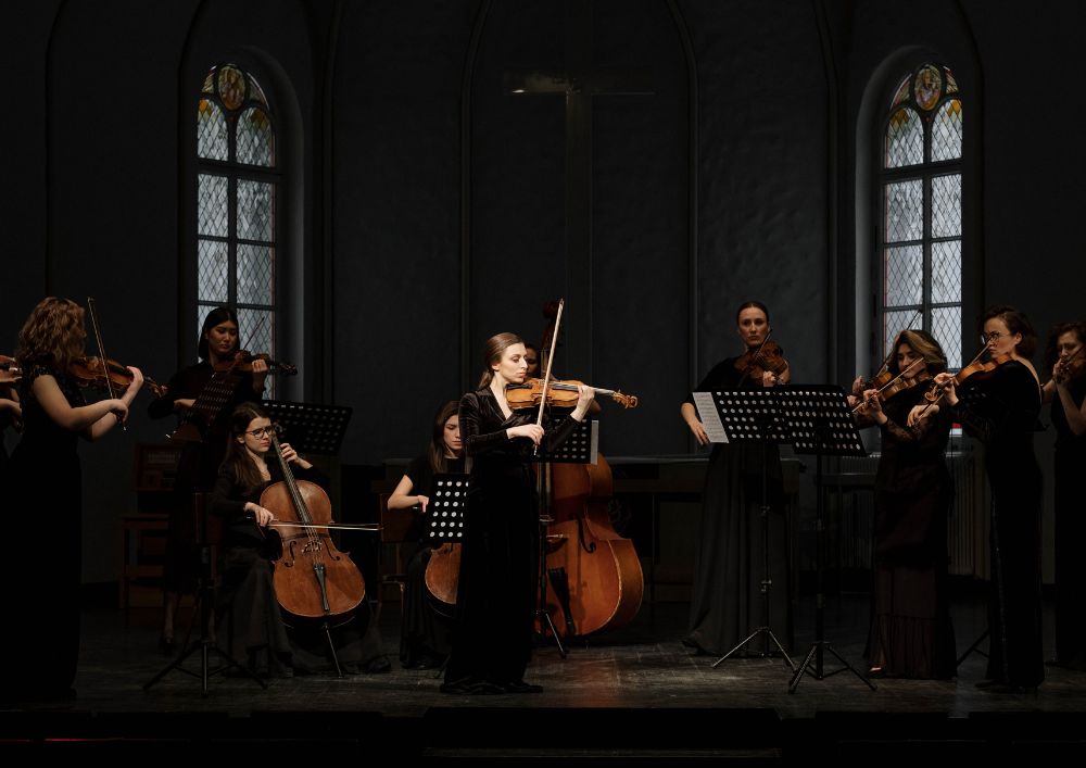 Group of women playing violins in a church. Enjoying music while creating harmonious melodies together.