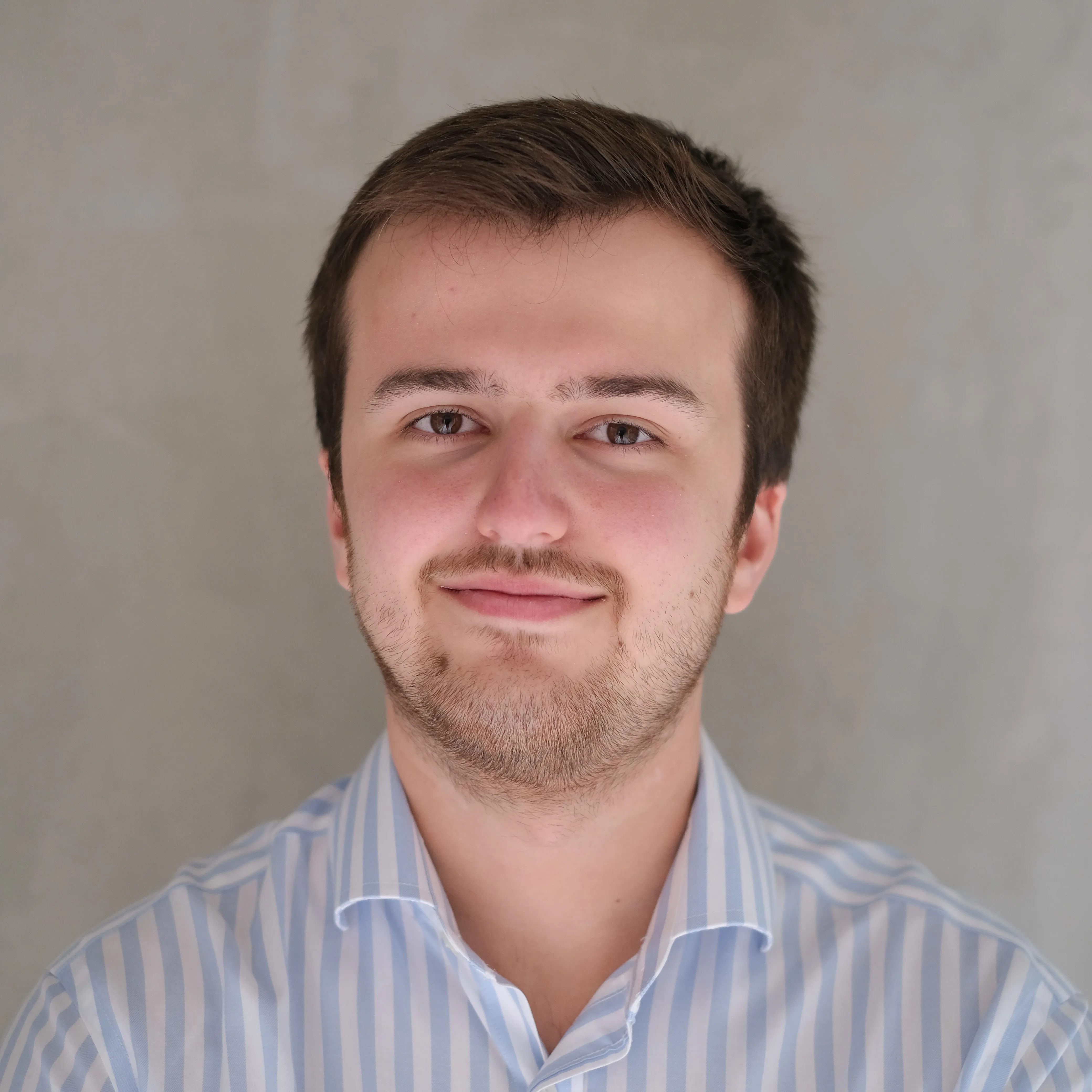 Webdesign-Experte aus Münster im gestreiften Hemd vor neutralem Hintergrund