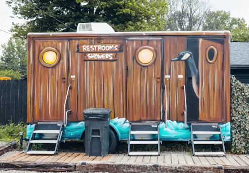 Modular restroom trailer painted like a log cabin