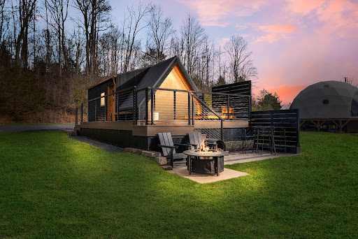 Star Farm A-frame at dusk with fire pit and deck chairs
