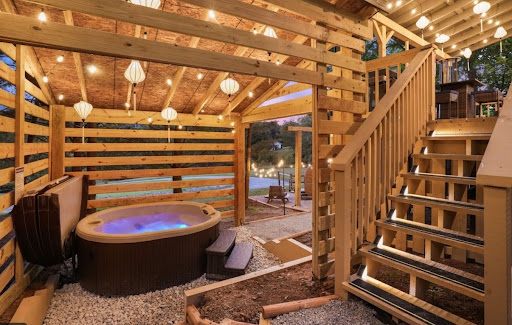 Metal-roof-covered pergola over hot tub at Immersive Escapes, evening lighting