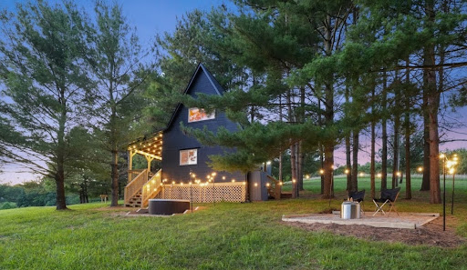 Immersive Escapes cabin at dusk, exterior lighting, fire pit area