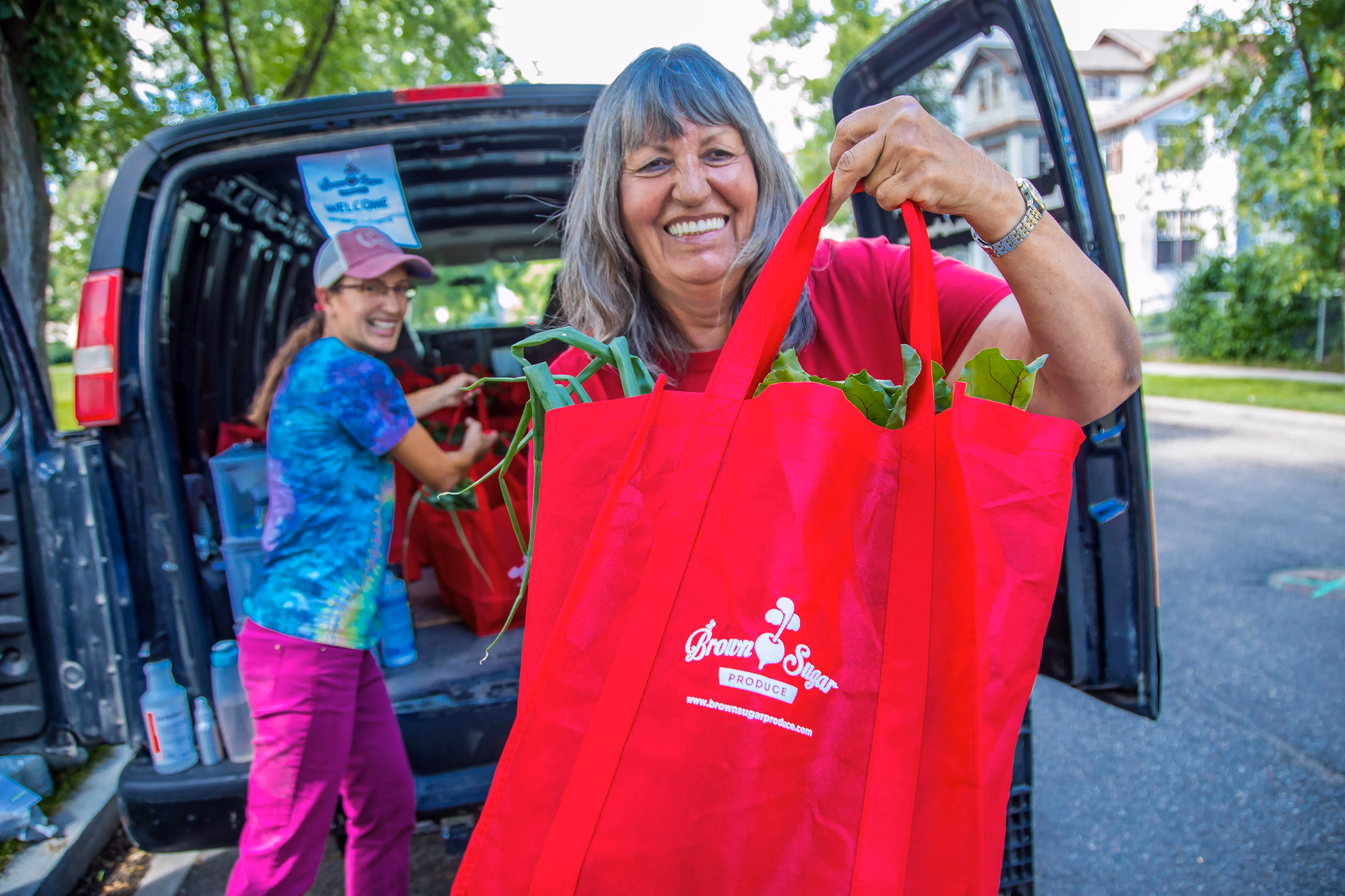 Brown Sugar Produce Success Story Local Line Handing out CSA Produce Bag to Customers