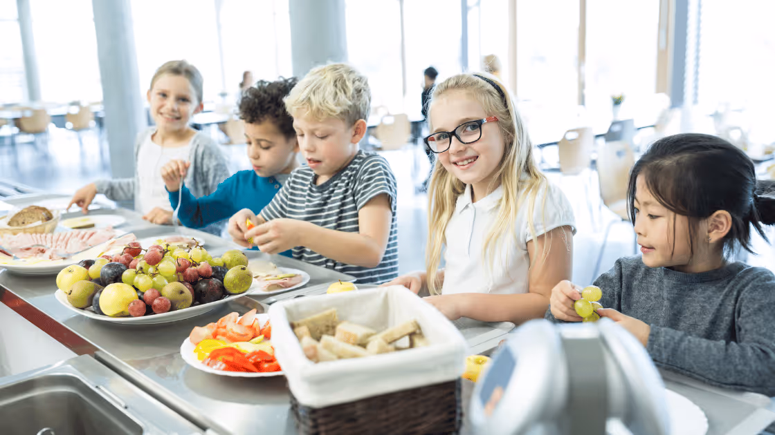 Children at a cafeteria eating a healthy school lunch
