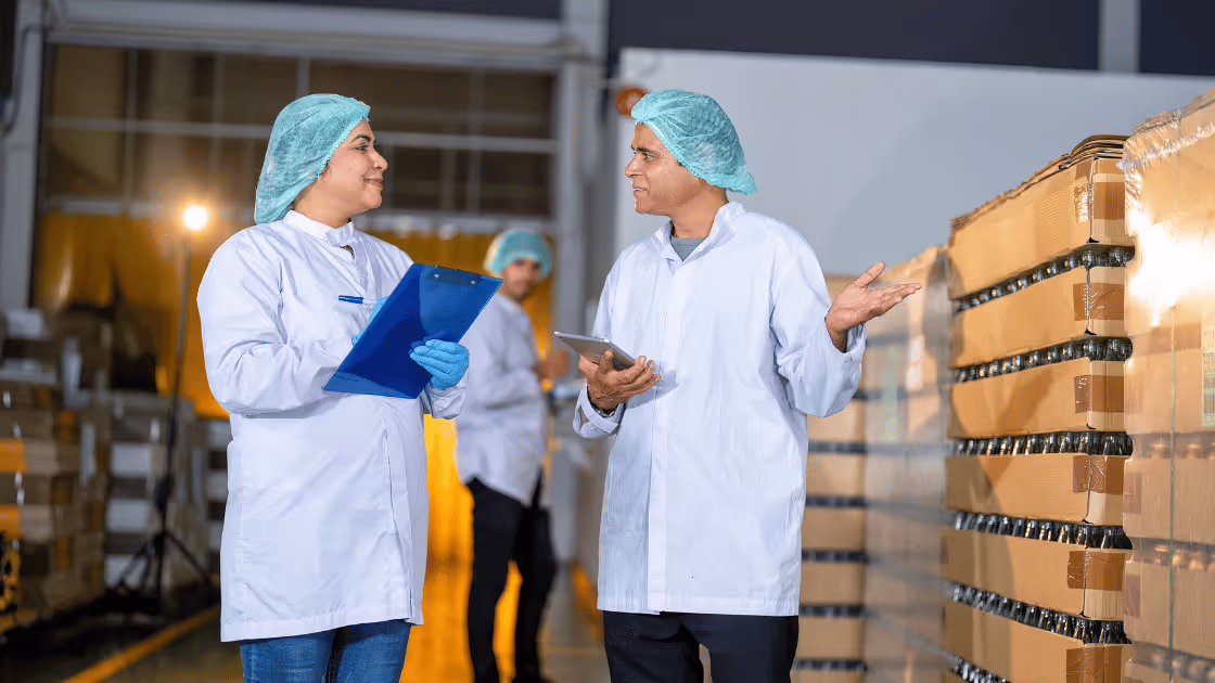 Two workers in a warehouse doing quality control for food products.