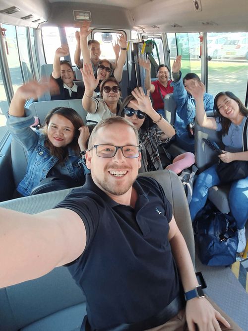 Groworx programme participants and colleagues smiling together on a bus