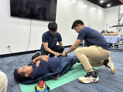 Groworx trainees practise a supported transfer in a care training room