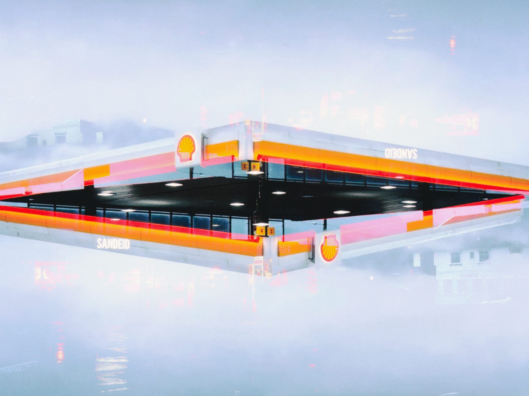 A petrol station forecourt mirrored into a floating symmetrical shape against a pale sky