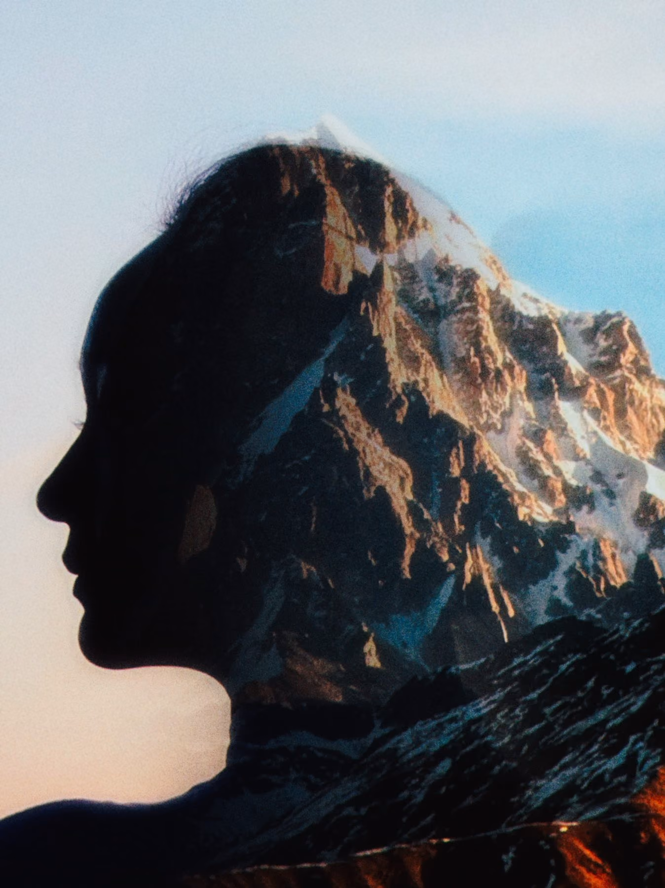 A profile silhouette blended with a snow covered mountain range
