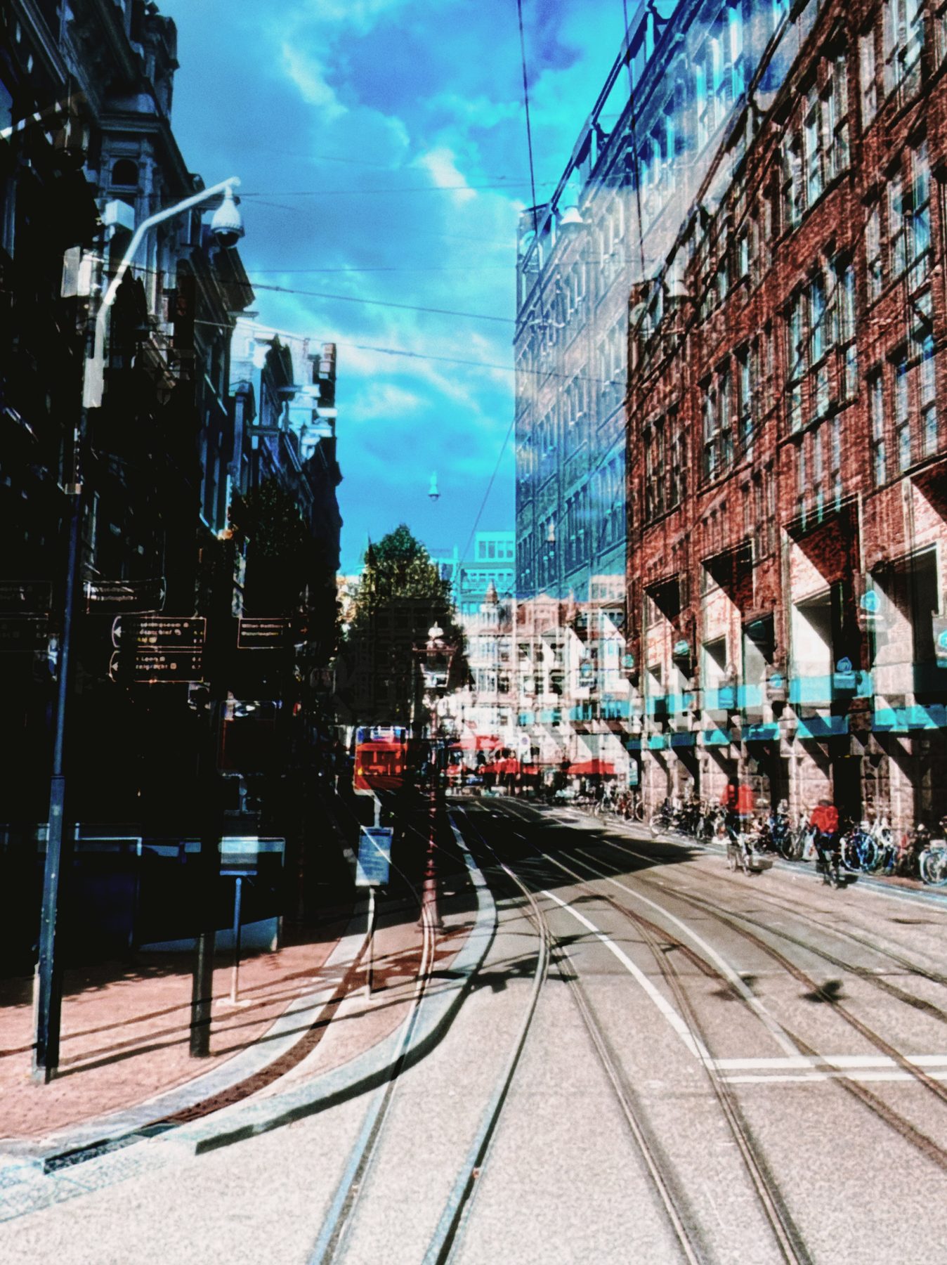 A city street with tram tracks, doubled slightly so the buildings echo themselves