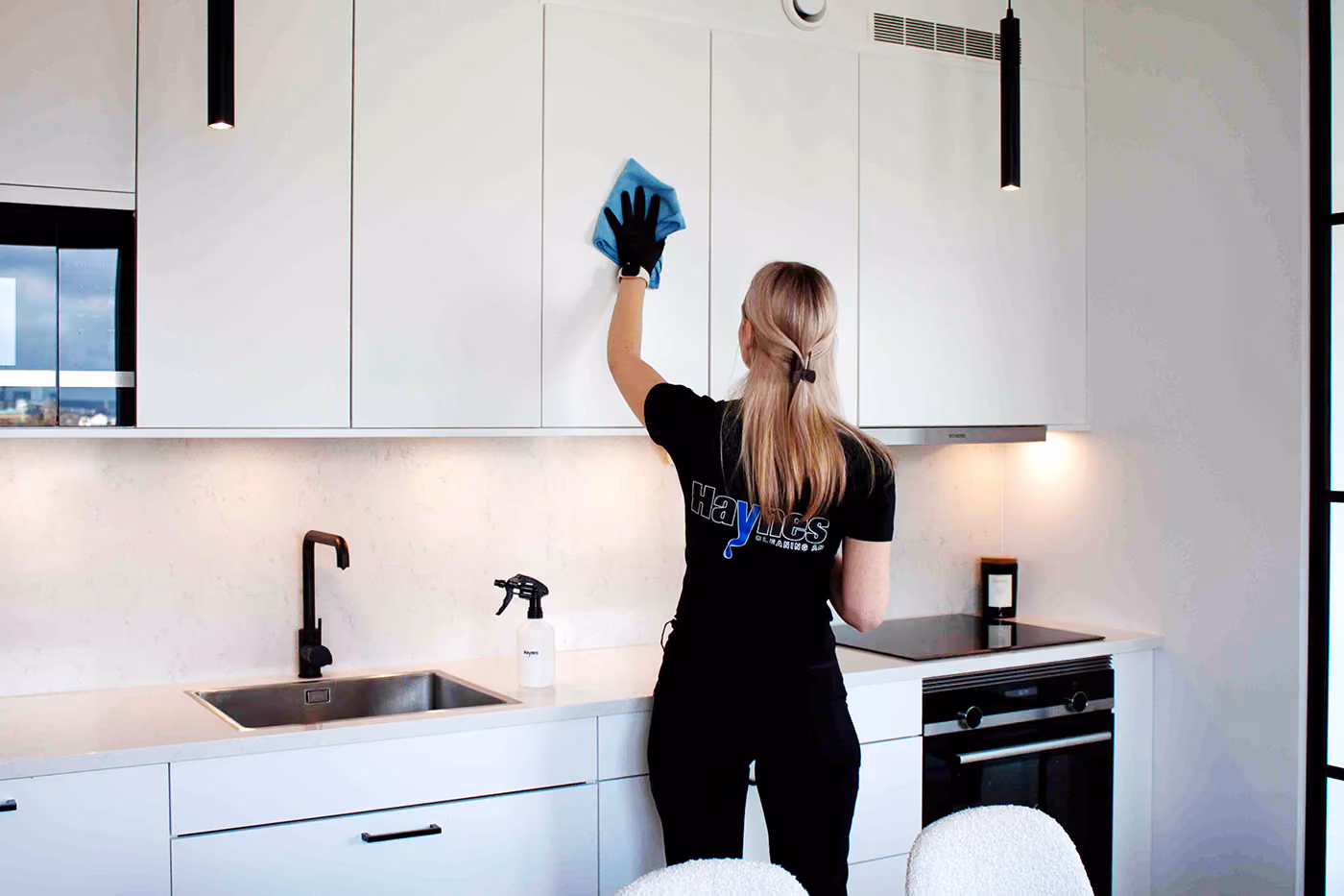 Städare från Haynes Cleaning torkar av köksskåp vid storstädning