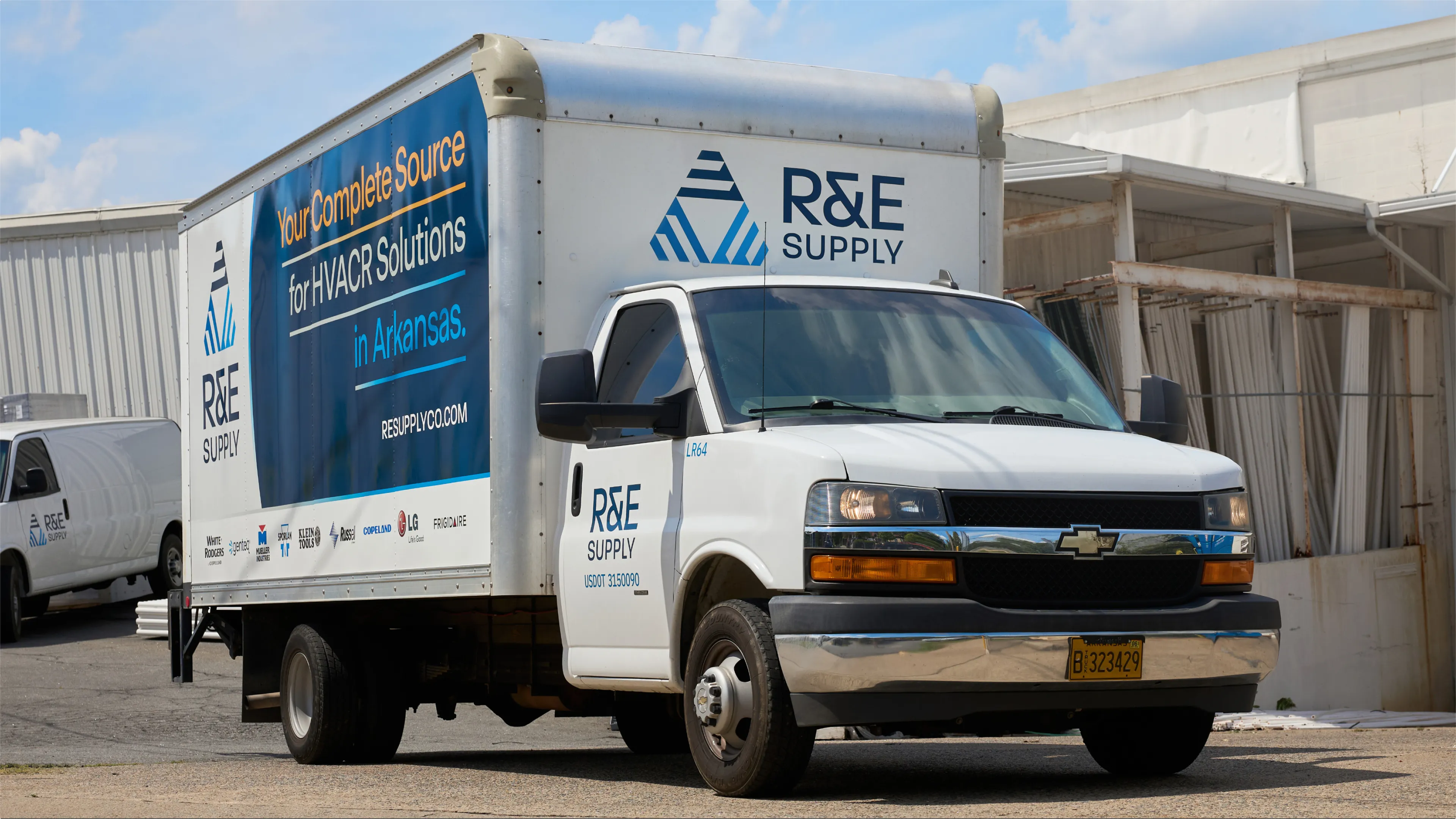 R&E Supply branded Chevrolet box truck with Your Complete Source for HVACR Solutions in Arkansas vehicle wrap photographed at wide angle at warehouse, vehicle branding by Unbound Collective