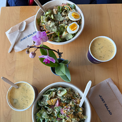 Wooden table with a salad and soups.