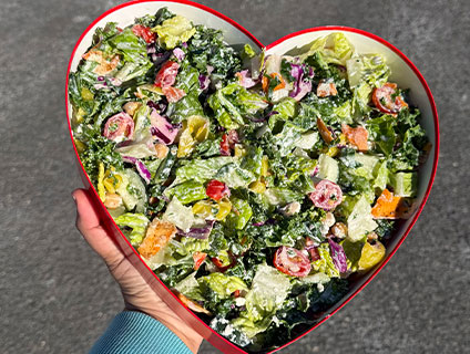 A salad in a heart shaped container.
