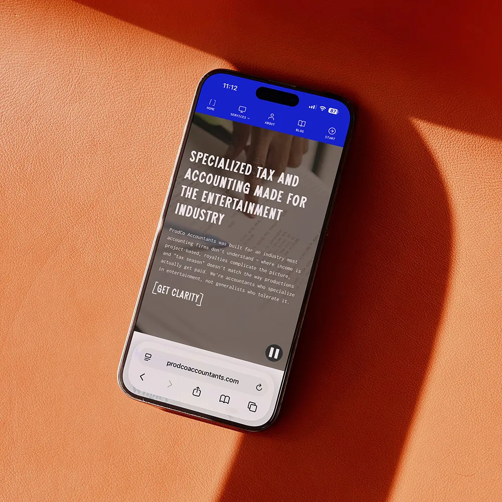 Prod Co Accountants mobile homepage displayed on a phone against orange leather