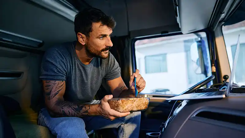 Man eating bowl of food in his truck