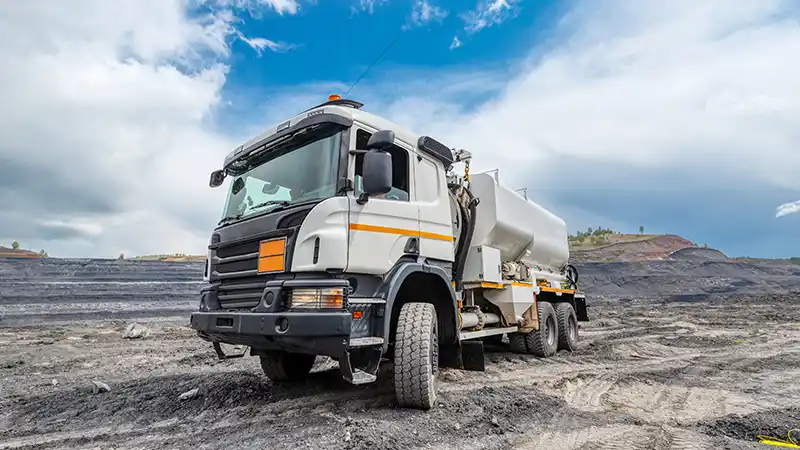 Commercial service truck driving on dirt road