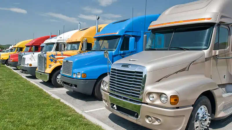 Commercial used semi trucks for sale sitting in dealership lot.