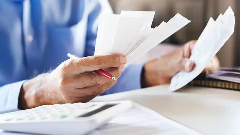 IFTA Filing Guide for Owner-Operators and Small Fleets Truck driver organizing fuel receipts and mileage records for IFTA filing.