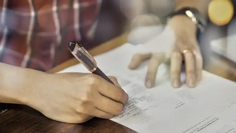 Owner-operator reviewing business formation paperwork at a desk with a truck outside.