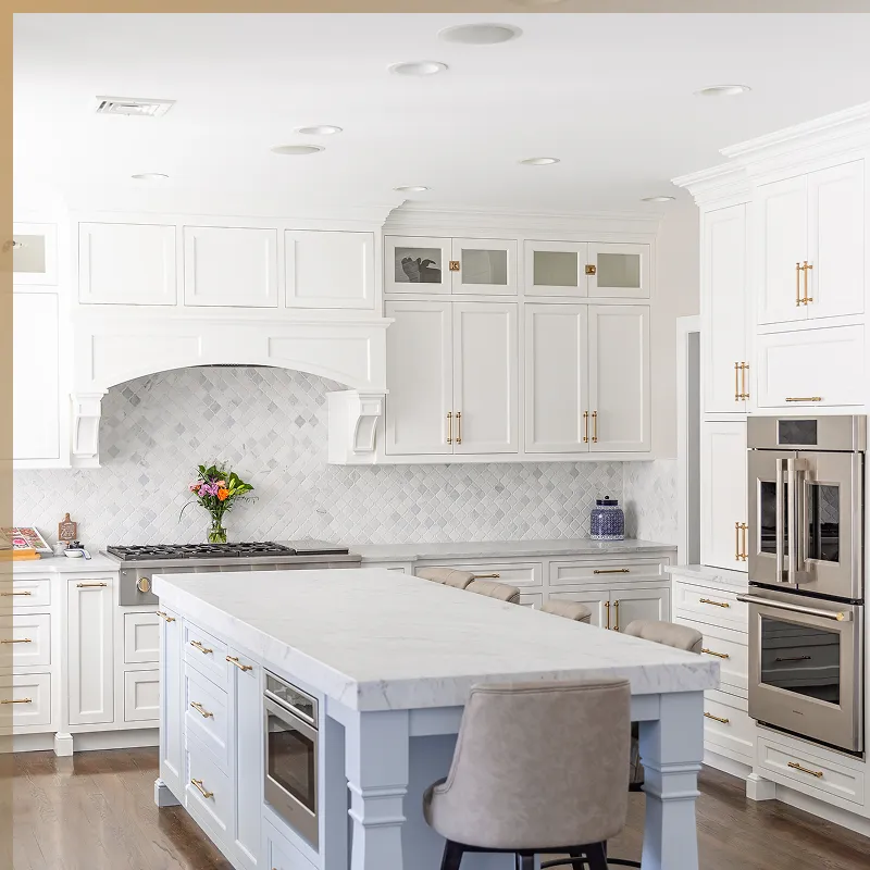 Modern kitchen with white cabinets, a marble island with built-in microwave, stainless steel appliances, and a light wood floor.