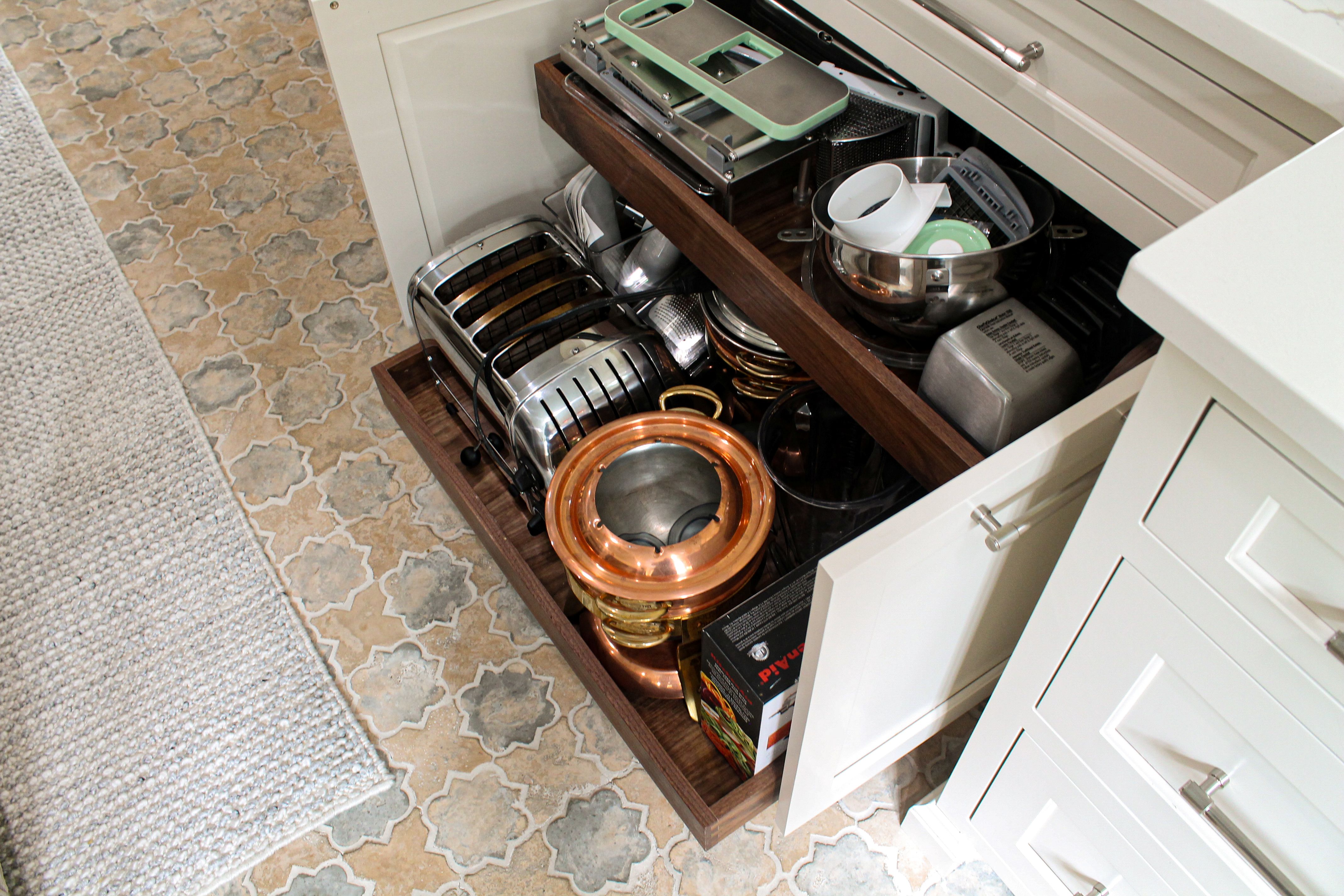 Pull-out drawer holding a toaster, mixing bowls, and cookware