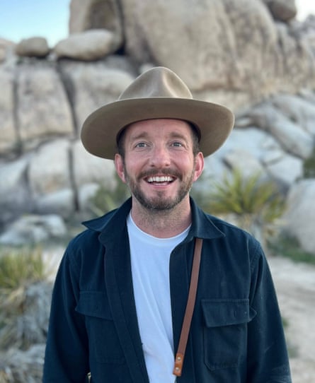 a man in a hat smiles broadly