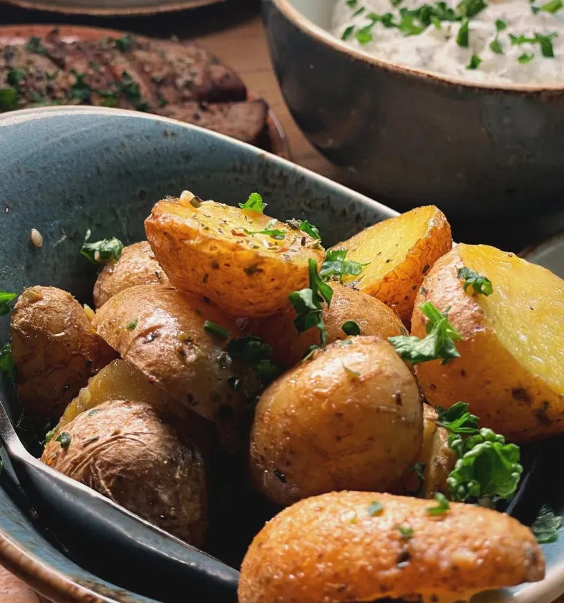 Knusprige griechische Ofenkartoffeln mit Kräutern als Beilage im Restaurant Mezedes in Hamburg.