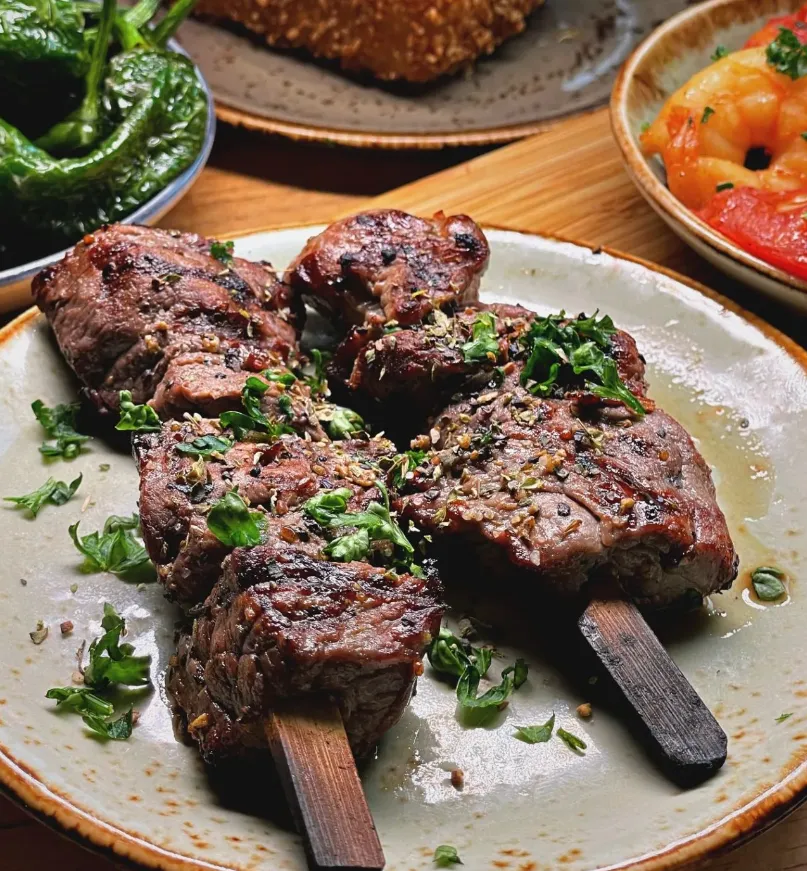 Griechischer Rinderspieß (Souvlaki) vom Grill mit Kräutern, serviert im Restaurant Mezedes in Hamburg.