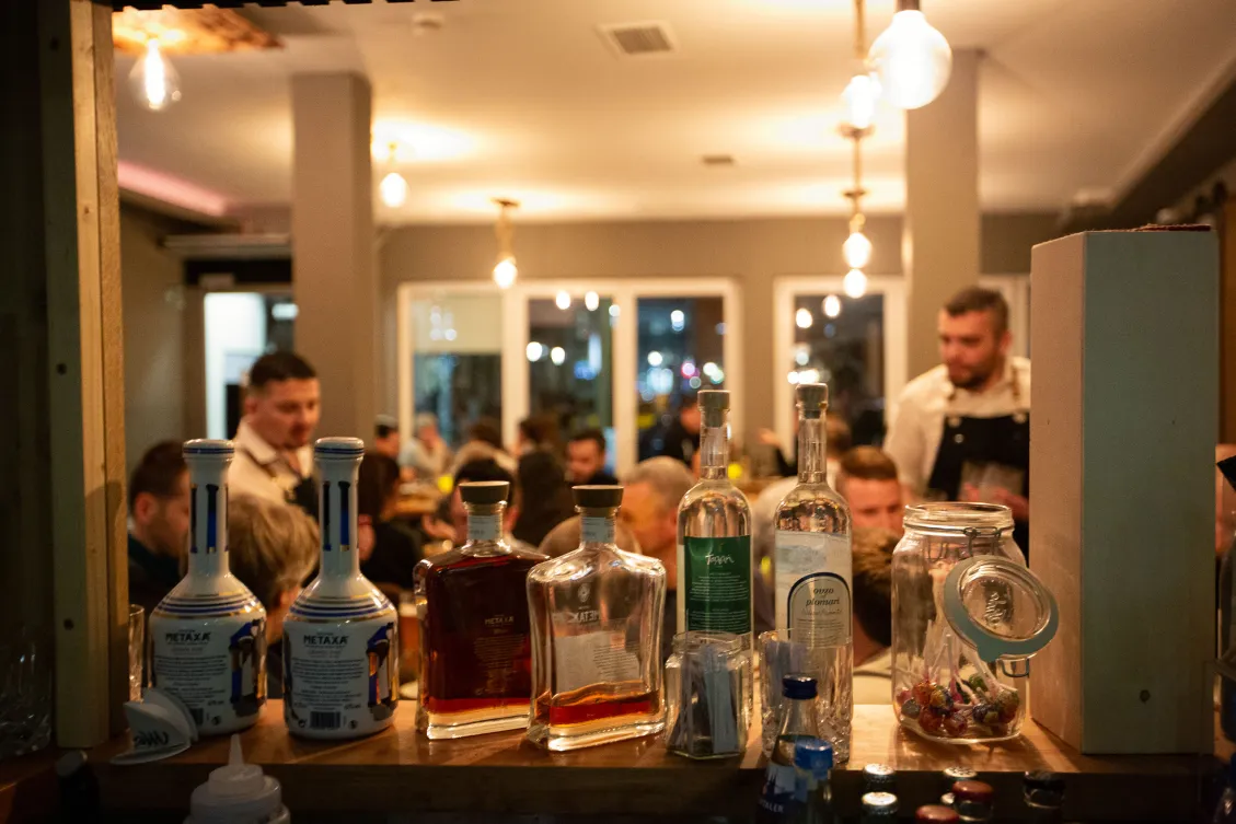 Abendstimmung im griechischen Restaurant Mezedes in Hamburg-Eppendorf mit Bar und Gästen.