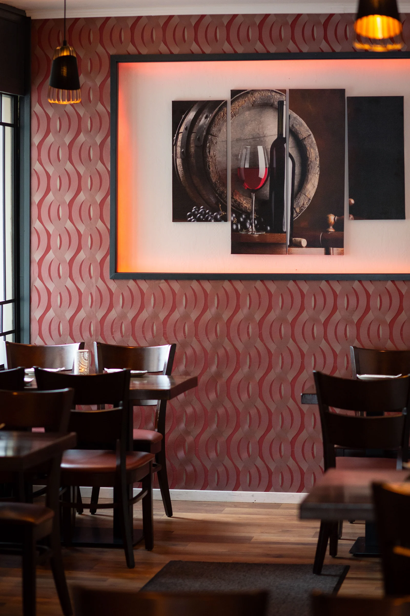 Gastraum des Restaurants Mezedes in Hamburg mit dekorativem Wandbild eines Weinfasses, Weinflasche und Weinglas.