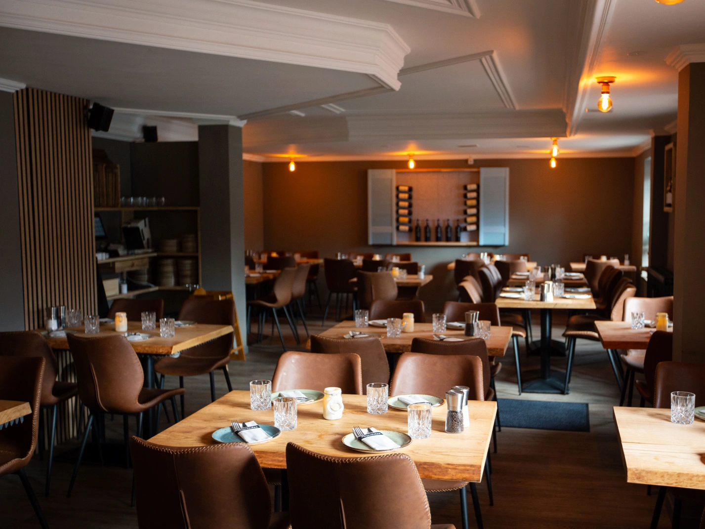 Moderner Gastraum des griechischen Restaurants Mezedes in Hamburg-Eimsbüttel mit eingedeckten Holztischen und gemütlicher Atmosphäre.