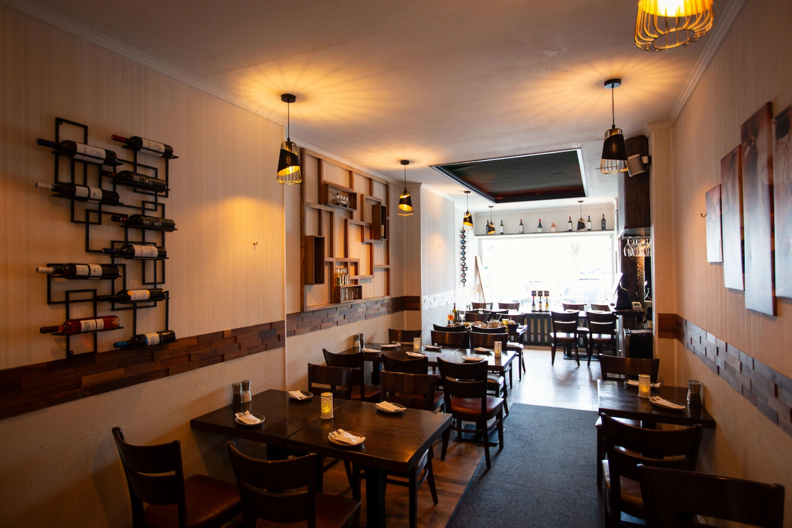 Gastraum des griechischen Restaurants Mezedes in Hamburg-Eppendorf mit eingedeckten Tischen, Weinregal und gemütlicher Atmosphäre.