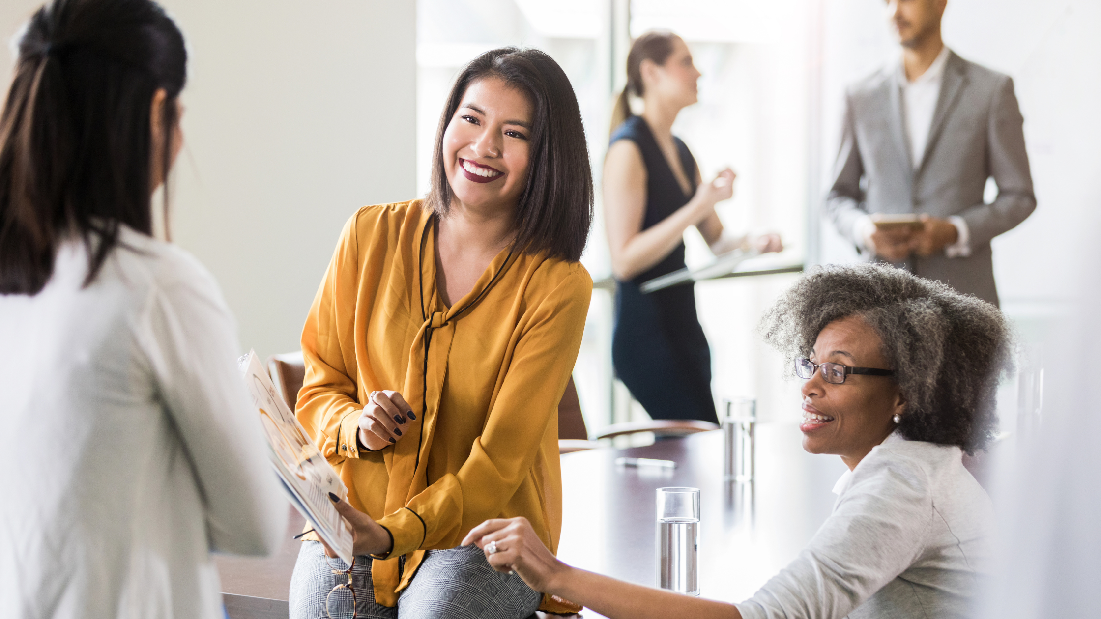 Diverse group of employees engage in a discussion at work