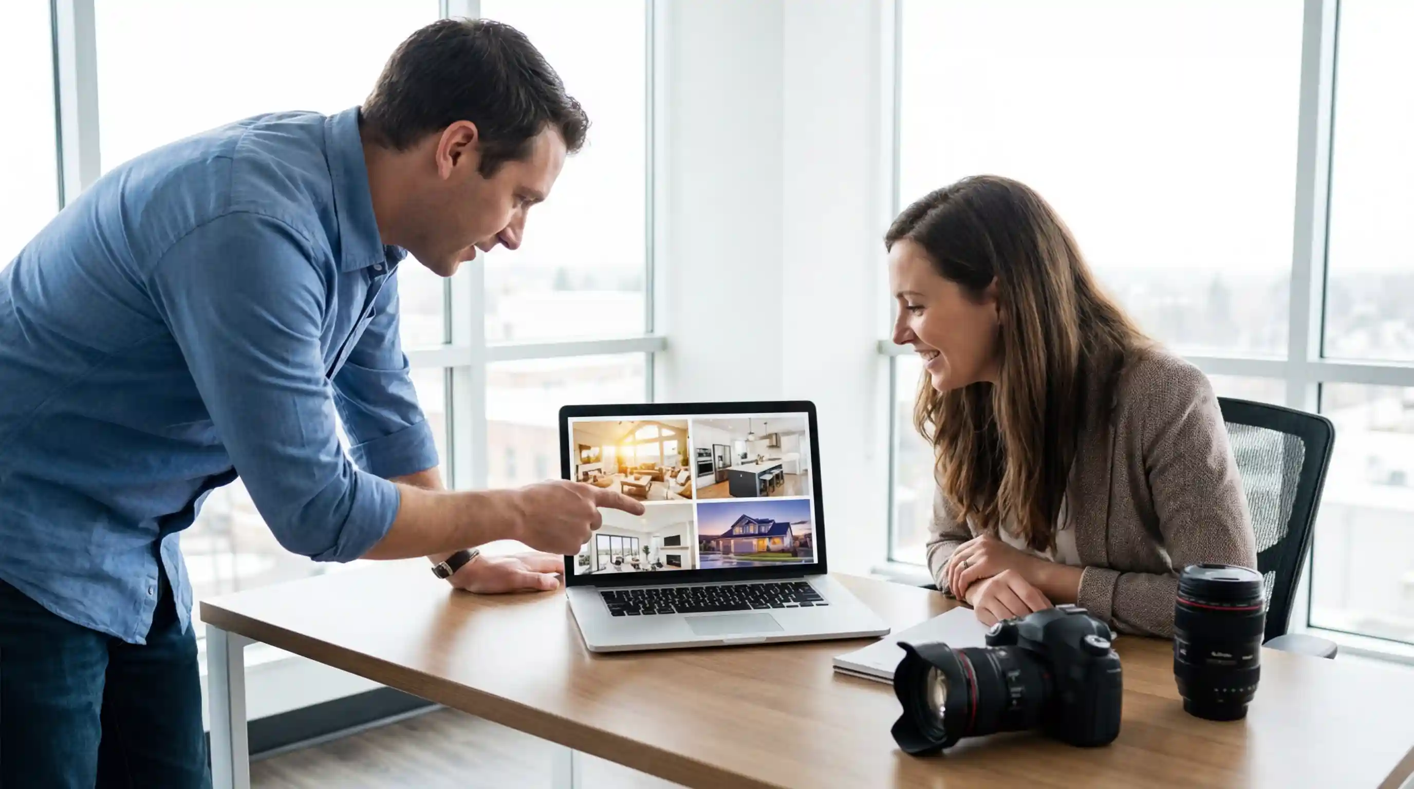 Real estate photographer presenting a property photo portfolio on a laptop to a client during a meeting