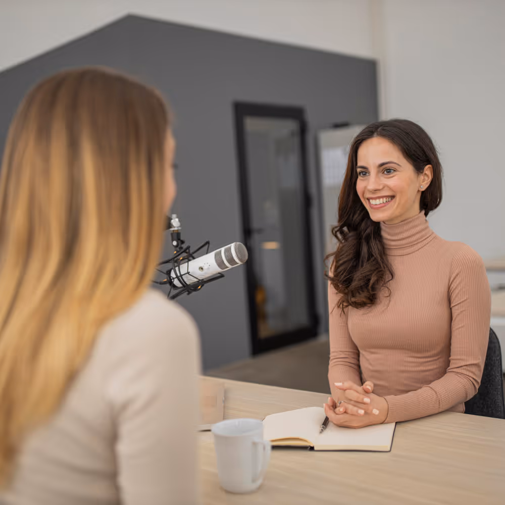 Ein Filmemacher der mit einem Notizbuch und Stift in der Hand neben einer Kamera steht.