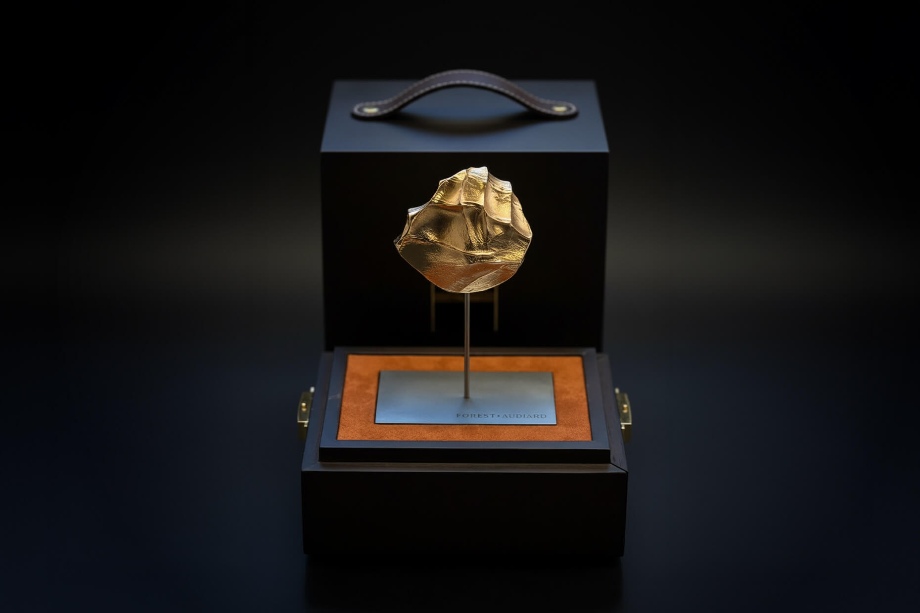 Sculpture L’Étreinte signée Forest Audiard, en bronze doré à l’or jaune 24 carats, présentée dans son écrin en chêne fumé.