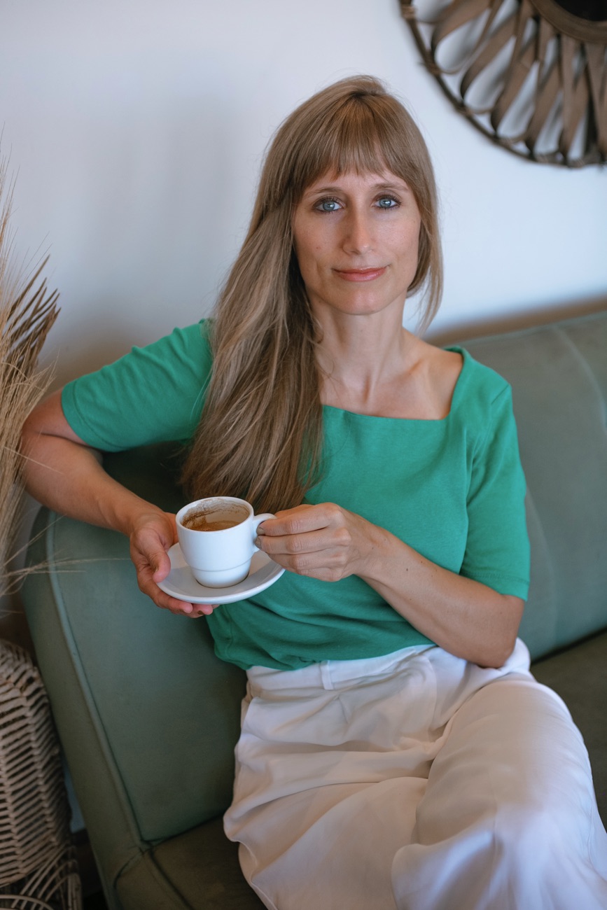 Sabine Bausch, sitting on sofa with coffee