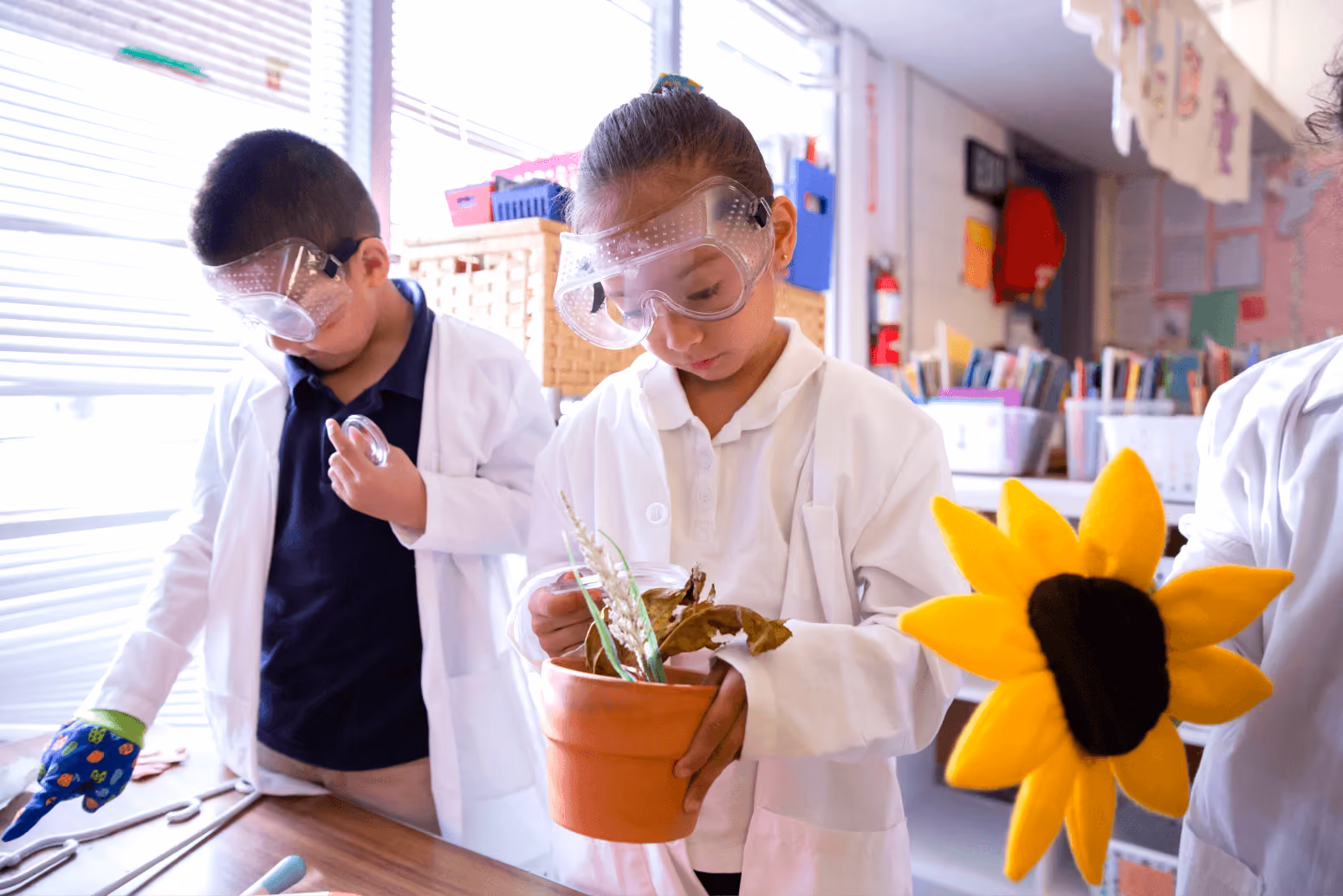 A group of kids in lab coats and goggles.