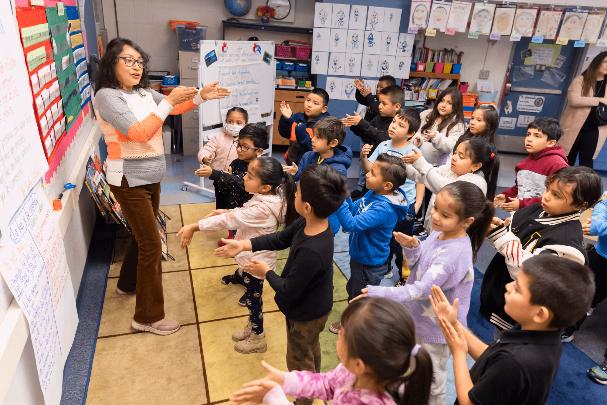 A woman teaching a class of children in a classroom.