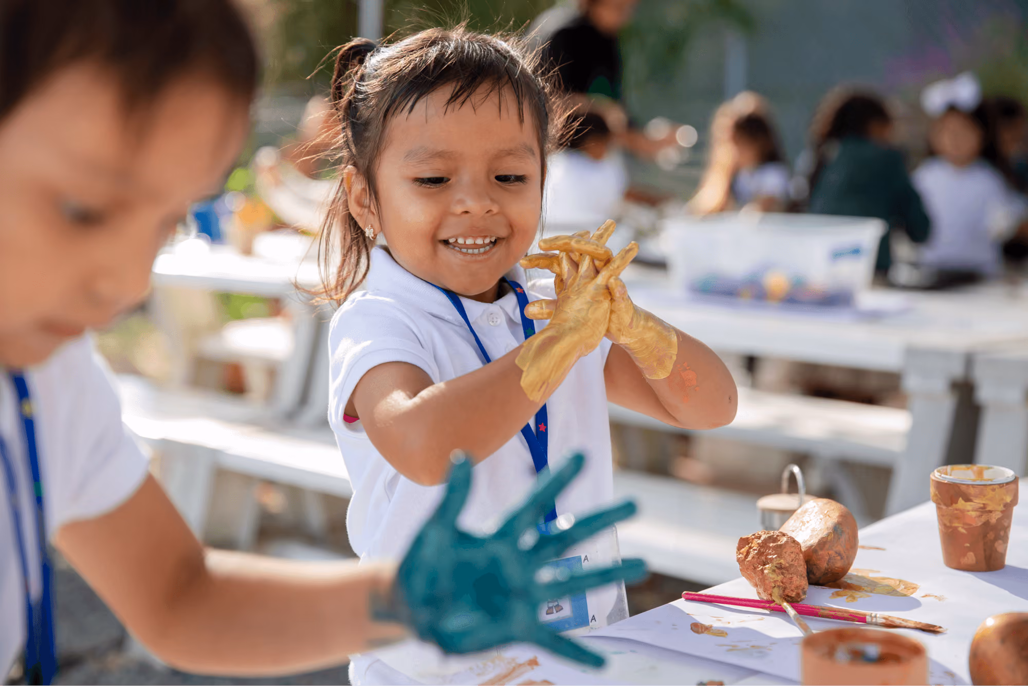 A little girl holding up a piece of food.