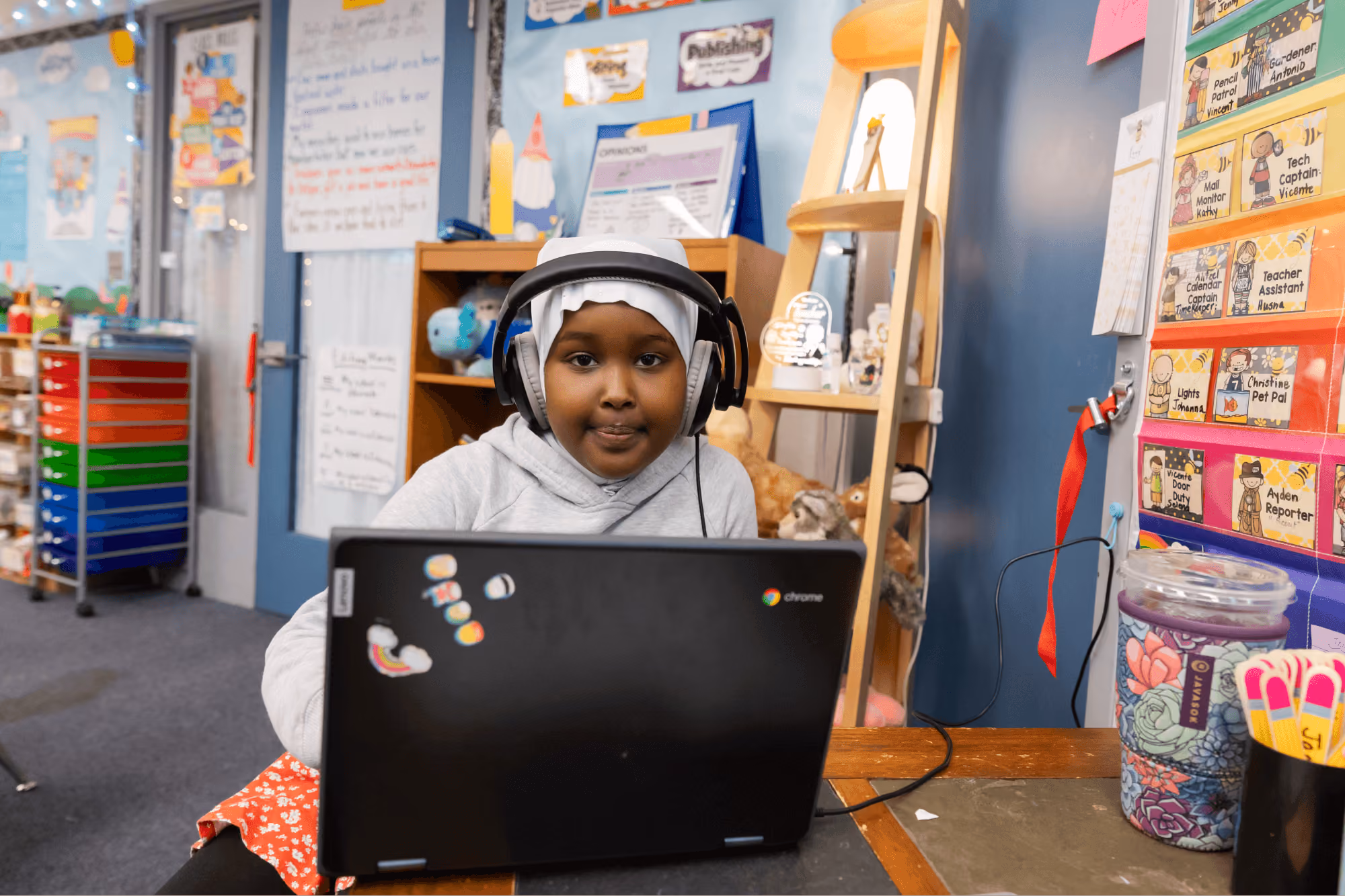 A young girl sitting in front of a laptop computer.