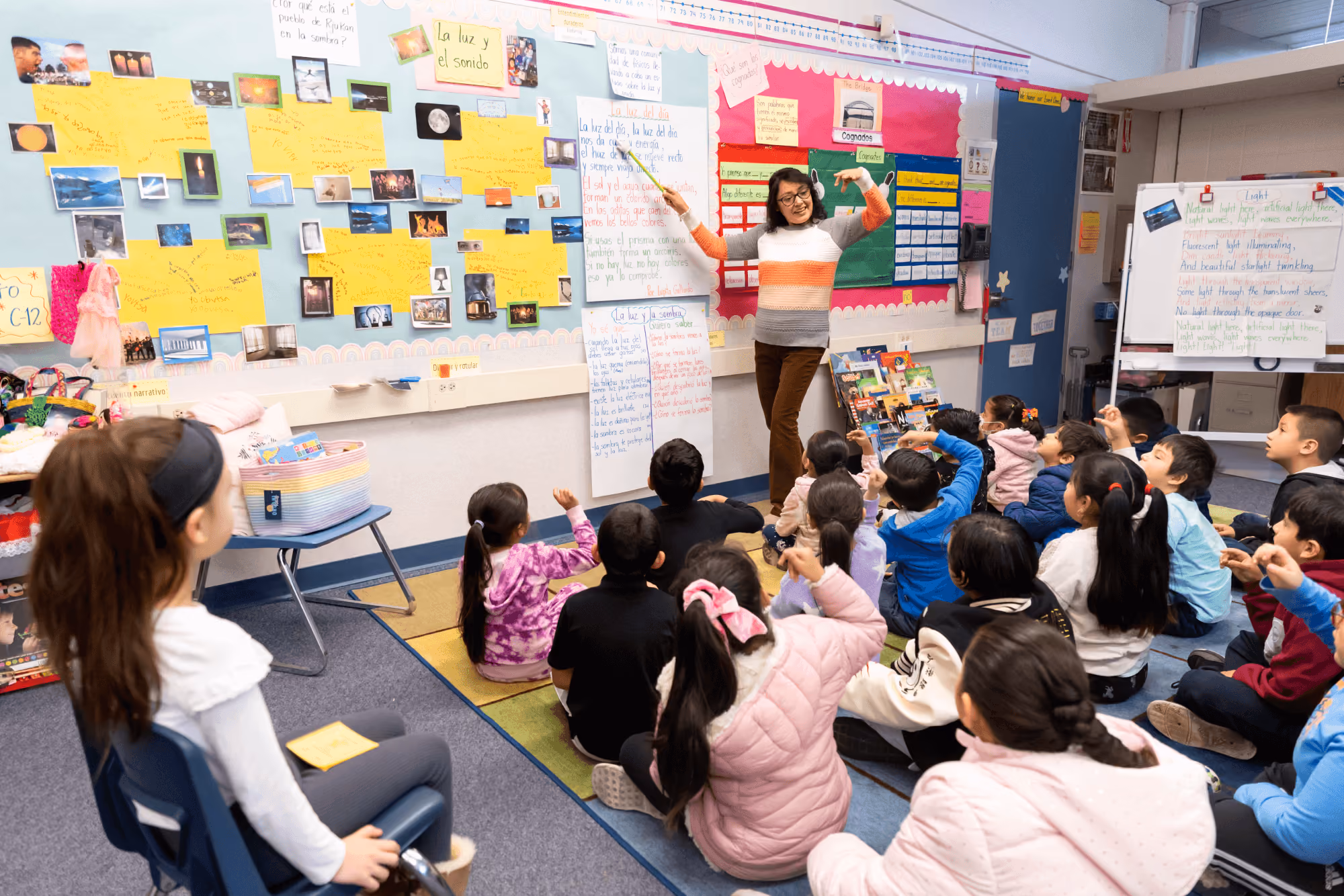 A teacher teaching a class of children in a classroom.