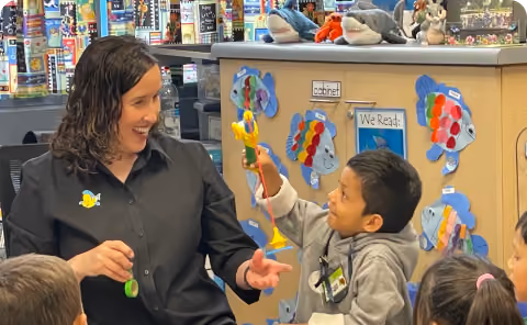 A woman teaching children how to use toothbrushes.
