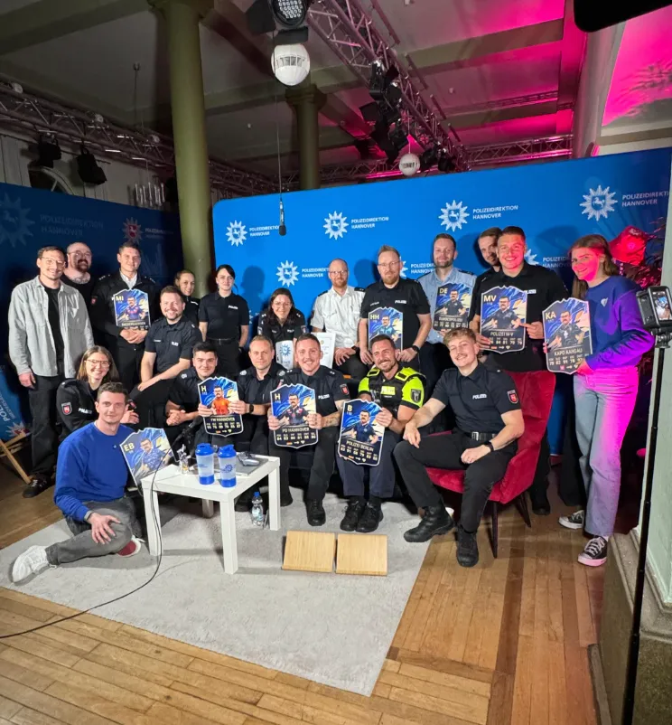 Zwei Menschen lächeln während einer Videokonferenz in einer Zoom-Sitzung, einer Frau mit langen braunen Haaren und eines Mannes mit hellbraunem Haar und Bart.